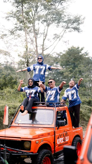 Tim wisata berfoto di atas kendaraan jeep